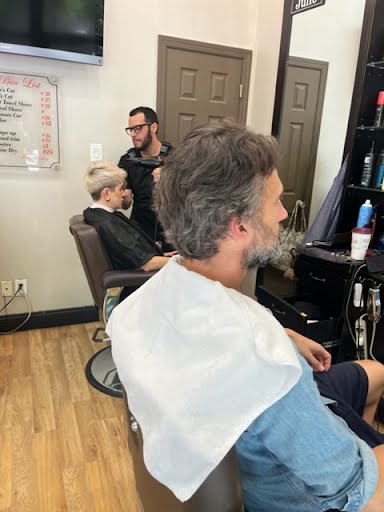 Barber cutting hair inside Deja Vu Barbershop